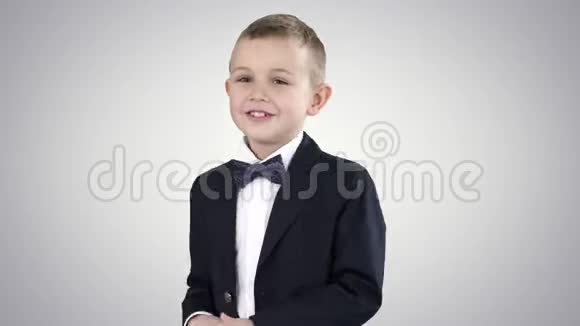 穿着正式服装的小男孩在渐变背景上说话和微笑视频的预览图