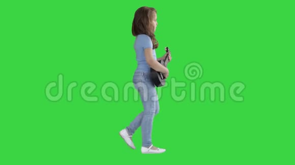 一个小女孩手里拿着四弦琴走在绿色屏幕上Chroma键视频的预览图