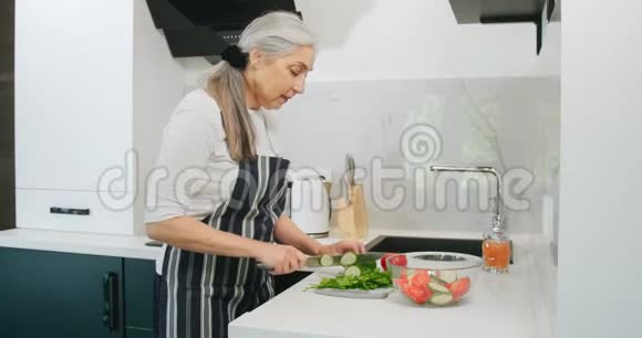老年妇女切沙拉厨房视频的预览图