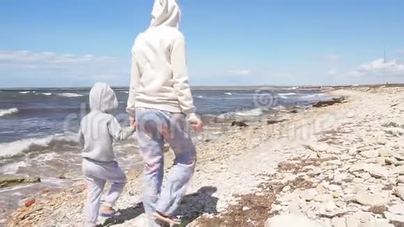 一家人沿着岩石海岸散步的慢镜头视频的预览图