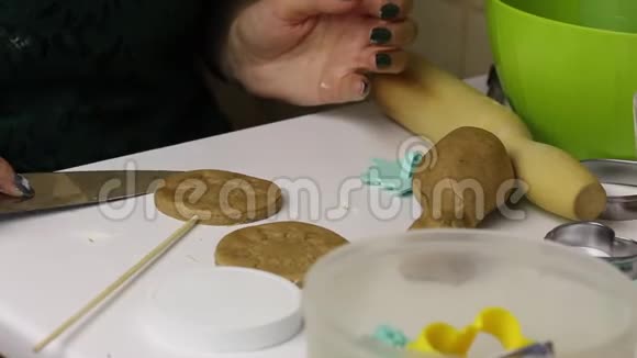 女人正在准备姜饼在她面前是一根棍子上的饼干切割机烘焙饼干堆放在旁边视频的预览图
