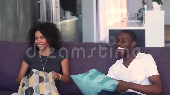 快乐的非洲裔父母玩孩子枕头大战视频的预览图