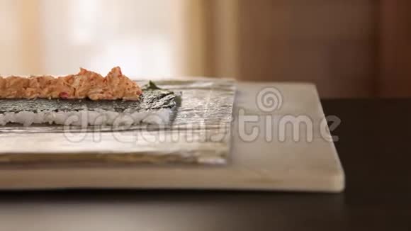 苏轼厨师汉兹的特写将熏鳗放在诺里叶和蟹肉上寿司制作工艺把寿司卷滚起来视频的预览图