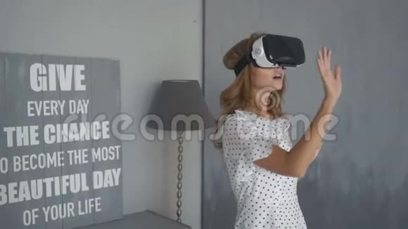当她试着用VR护目镜时兴奋的女人张开嘴与虚拟环境互动视频的预览图