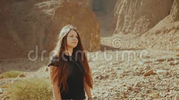 旅游妇女沿着岩石峡谷散步在炎热的沙漠拍照沙漠峡谷背景埃及西奈慢视频的预览图