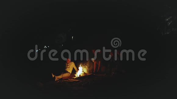 一群朋友晚上在海边的篝火旁玩快速视频慢动作全高清视频的预览图