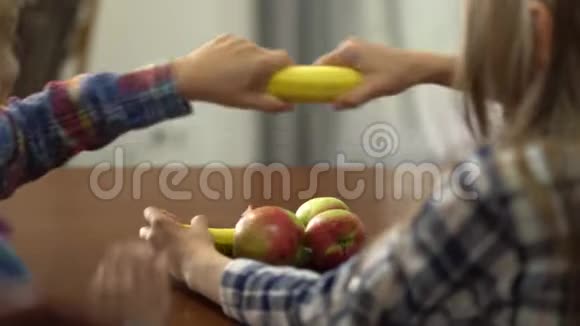 两个可爱的孩子在厨房里拿着香蕉像武器一样胡闹男孩和女孩在一起健康视频的预览图