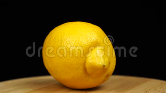 黄色柠檬放在木板上旋转360度黑色背景视频的预览图