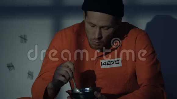 饥饿的白种人囚犯在牢房里吃饭可怕的恶心食物条件视频的预览图