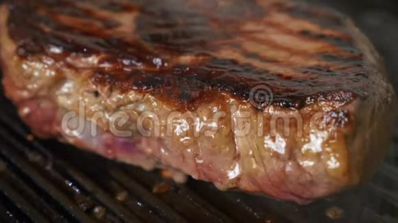 在网格上关闭牛肉牛排烧烤在烧烤上烹饪果汁牛排视频的预览图