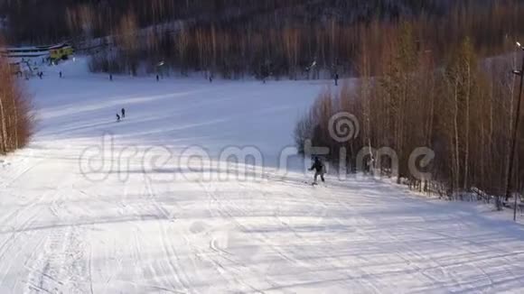 滑雪者在一个阳光明媚的冬天从山顶滑下来阿里尔的观点滑雪的概念视频的预览图