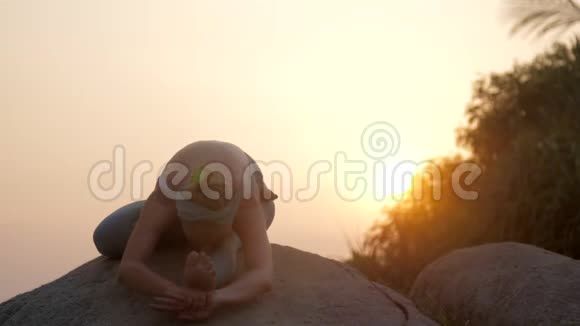 女人在亚萨纳放松在大岩石慢运动视频的预览图