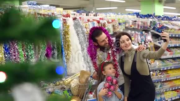 幸福的一家人带着圣诞礼物在超市自拍视频的预览图