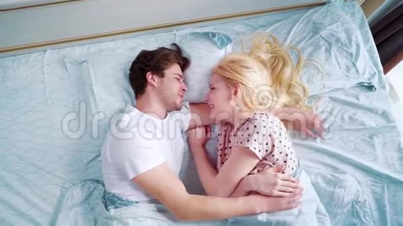 在早晨的床上放大年轻的微笑情侣视频的预览图