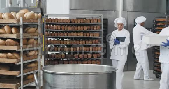 面包业的大厨师穿着特别的制服准备面团从篮子里加入一些面粉面包师视频的预览图