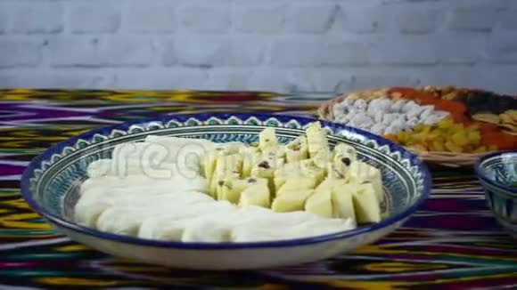 乌兹别克斯坦撒马尔罕咖啡馆的桌子上拿着一些东方糖果的女人视频的预览图