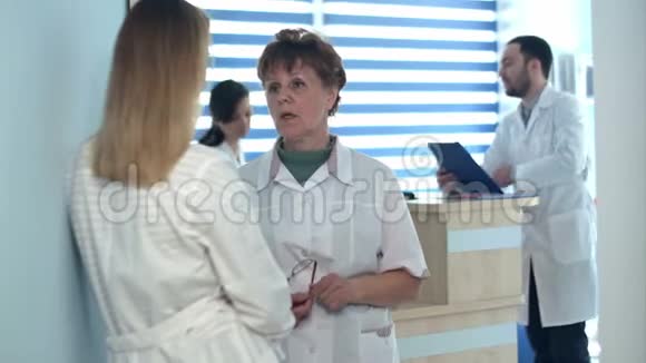 两名护士在接待处附近交谈视频的预览图