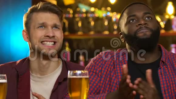多种族朋友在酒吧里看体育比赛为不同的球队加油视频的预览图