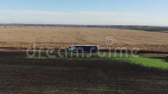 半卡车货物拖车在土路上行驶白色卡车穿过玉米地背景视频的预览图
