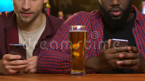 体育迷在智能手机上下注在酒吧里看足球比赛胜利视频的预览图