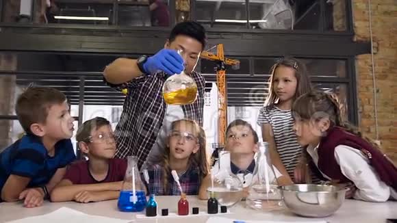 科学家教孩子们如何在实验室里做化学反应实验眼镜中橙色化学反应视频的预览图