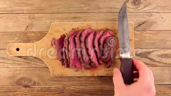 男人手把旧刀放在木板上上面放着中熟烤牛肉视频的预览图