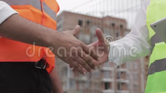 两位建筑师工程师在施工现场握手快关门视频的预览图
