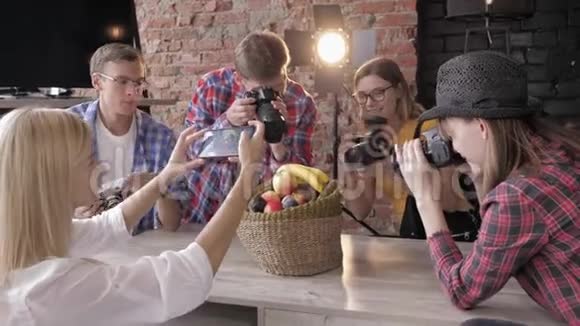 摄影棚里有设备的大师班年轻的摄影师学会用照相机在篮子里拍照水果视频的预览图