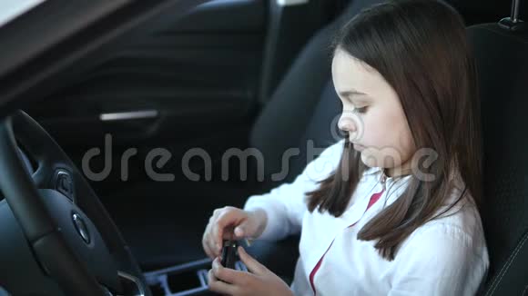 一个漂亮的女婴坐在一辆新车里一边看一边笑一边看着车上的汽车视频的预览图