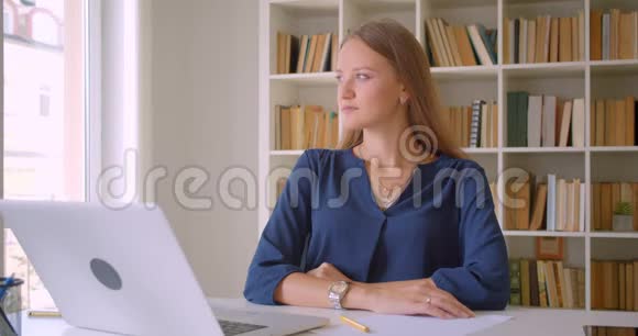 年轻漂亮的白种人女商人的特写镜头她正开心地坐在办公桌前看着镜头视频的预览图