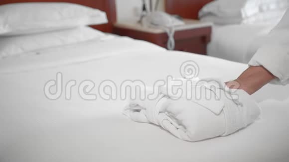 未被识别的成年高级妇女在酒店房间的床上穿着一件白色长袍服务和清洁的概念视频的预览图