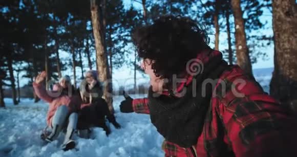 一个长着卷发的帅哥和他的两个朋友在森林中的冬天享受时光视频的预览图