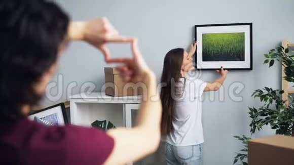 新房子的主人女孩和男人选择了拍照和打手势的地方视频的预览图