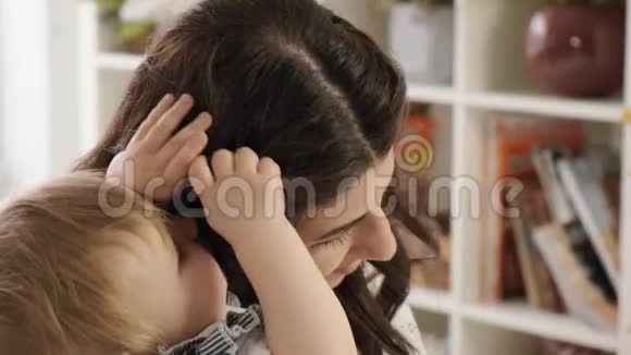 小女孩抚摸妈妈她的头发被父母紧紧地拥抱视频的预览图