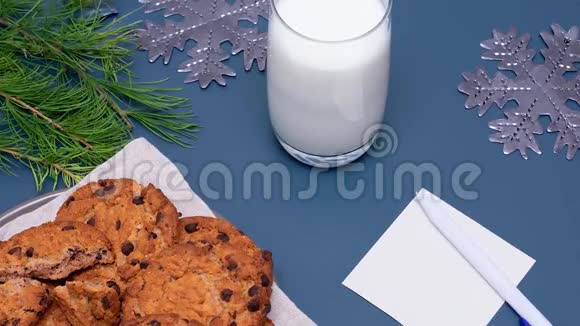 牛奶巧克力饼干和圣诞老人的纸条注意圣诞老人在普通背景上的位置假日概念新Y视频的预览图