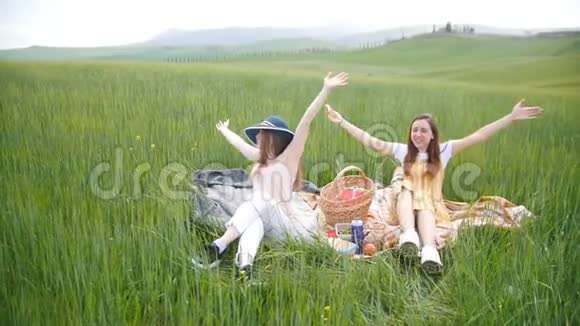 两个年轻漂亮的女人坐在草地上笑视频的预览图