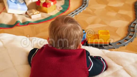 特写4k小男孩躺在地上看着玩具火车的镜头视频的预览图