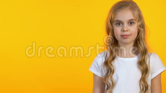 微笑的女孩用手指指着黄色背景上的空隙模板视频的预览图