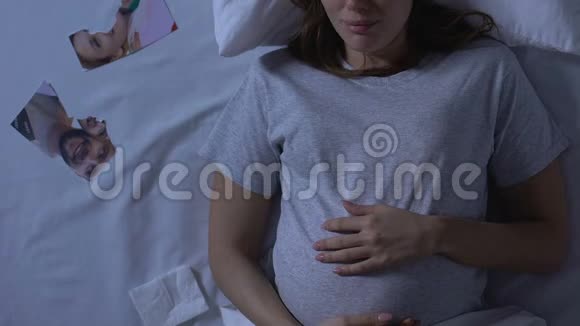 孕妇在床上哭泣附近的家庭照片被撕破背叛和离婚视频的预览图