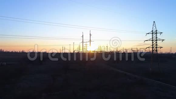 电力和环境问题美丽橙色下的高压塔和电力线的鸟瞰图视频的预览图