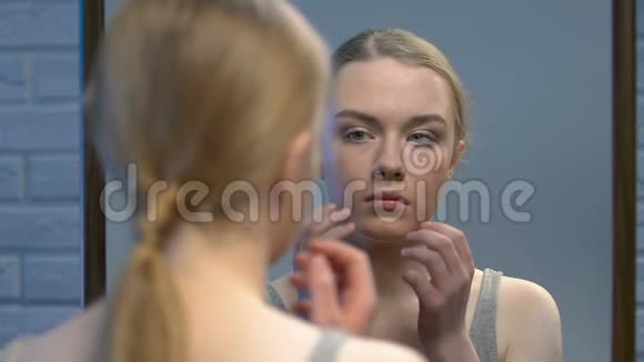 害羞的年轻女士照镜子用手闭上脸皮肤不完美视频的预览图
