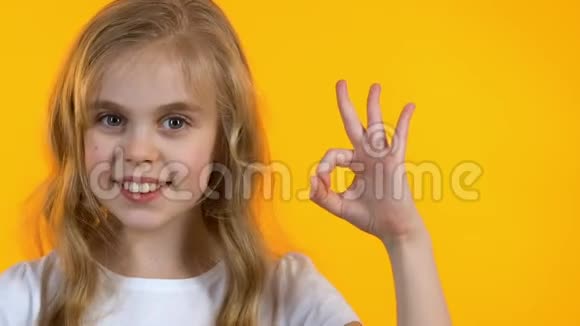 微笑的小女孩表现出良好的标志和眨眼孩子对新学校感到满意视频的预览图