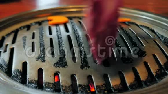 韩国餐馆铁烤盘上厨师手工烹制韩国烤肉的特写镜头韩式烧烤红肉视频的预览图