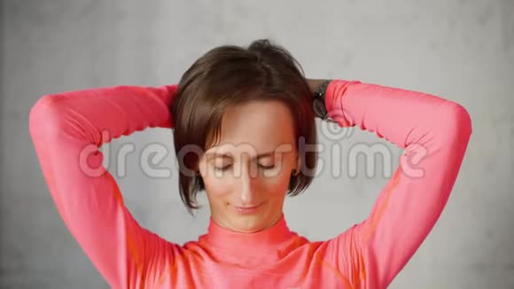 女人把手放在头背上把头向前倾斜伸展颈部肌肉视频的预览图
