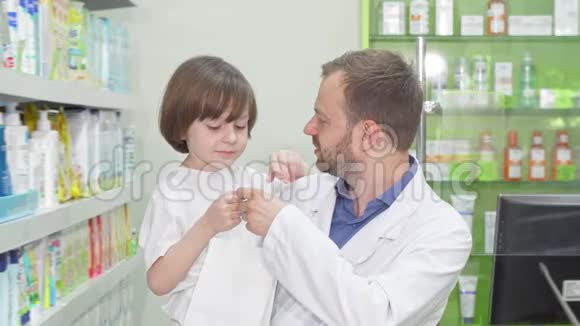 快乐的药剂师带着一个可爱的小男孩对着镜头微笑视频的预览图