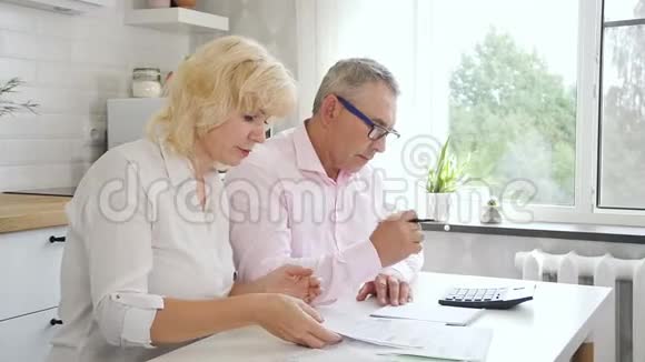 退休的男人和女人在家里计算账单视频的预览图