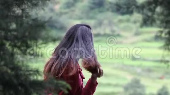 年轻的千禧年少女坐在户外梳头视频的预览图
