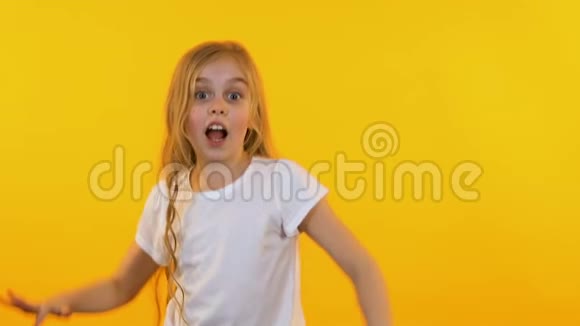 在黄色背景下跳舞的快乐女孩动作缓慢视频的预览图