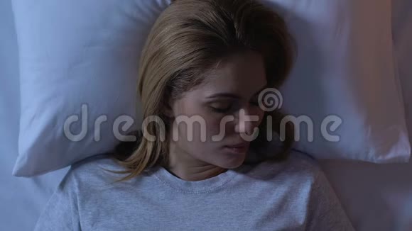 美丽的女人睡在床上在漫长的一天之后的夜晚放松俯瞰美景视频的预览图