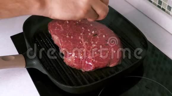 一个人手盐一个生牛排烧烤盘在白色厨房自制肋骨眼视频的预览图